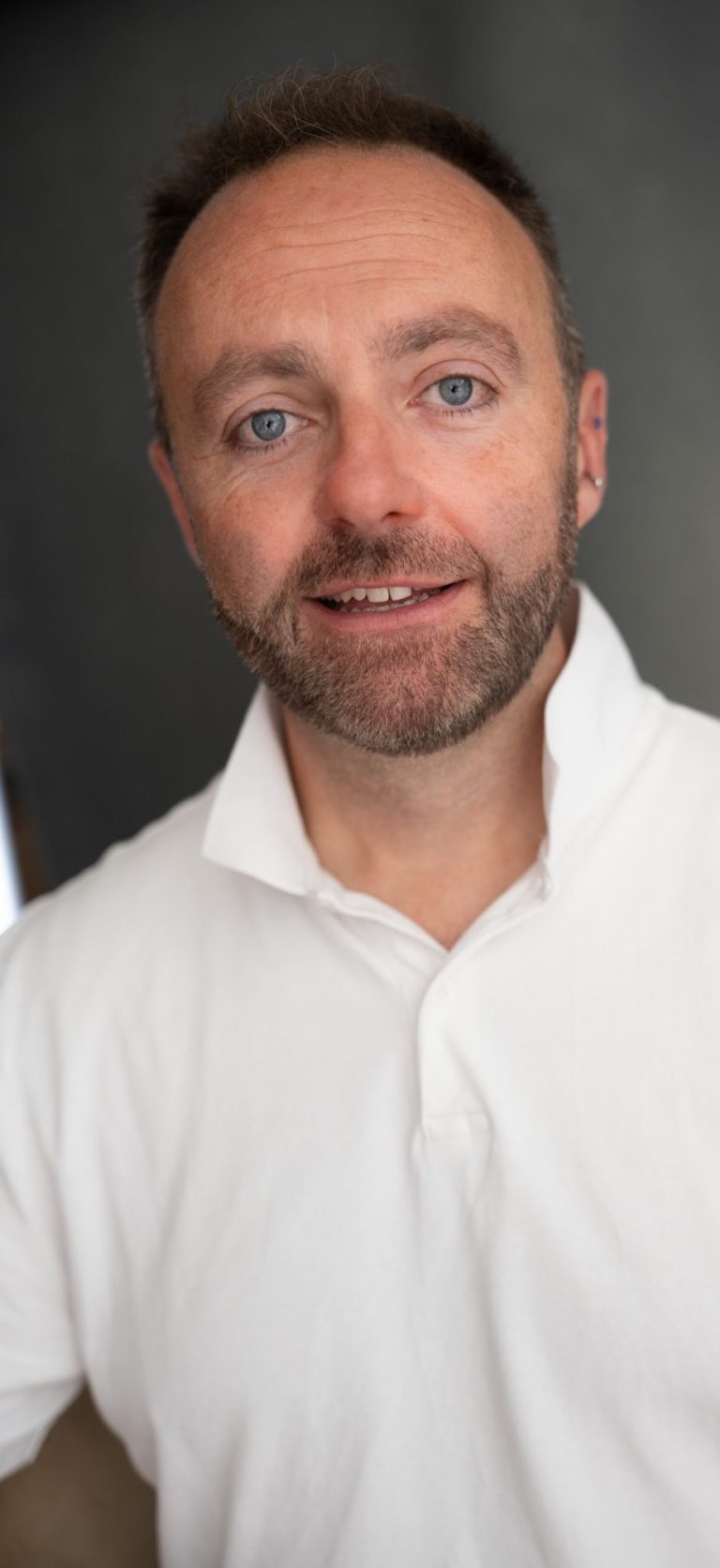 Jamie Read - professional vocal coaching Jamie Read is a middle aged white man wearing a white T-shirt and smiling. He has short brown hair and a beard